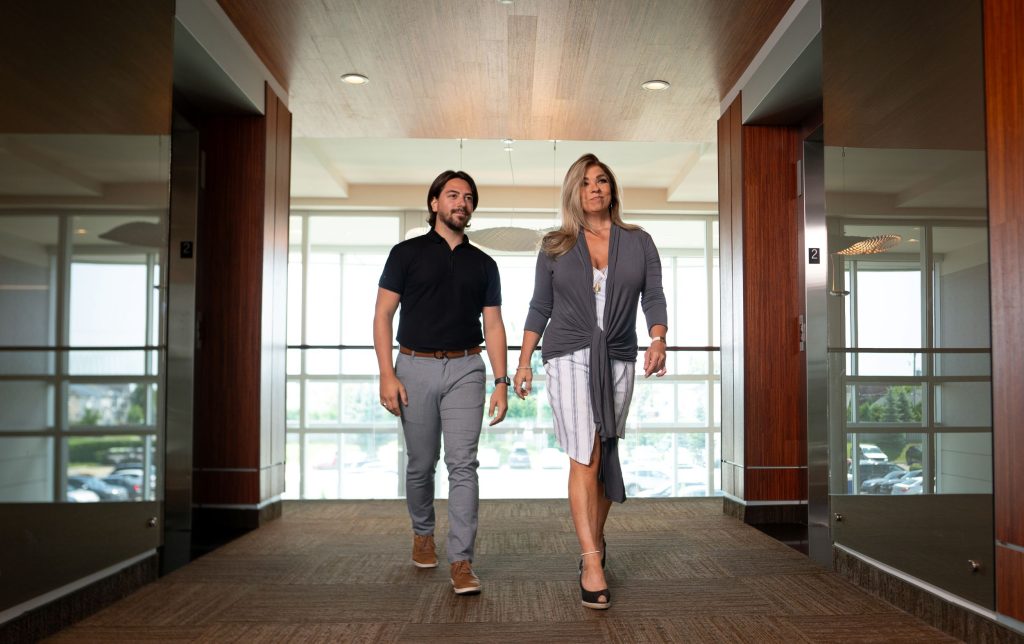 Two people walking down an office hallway