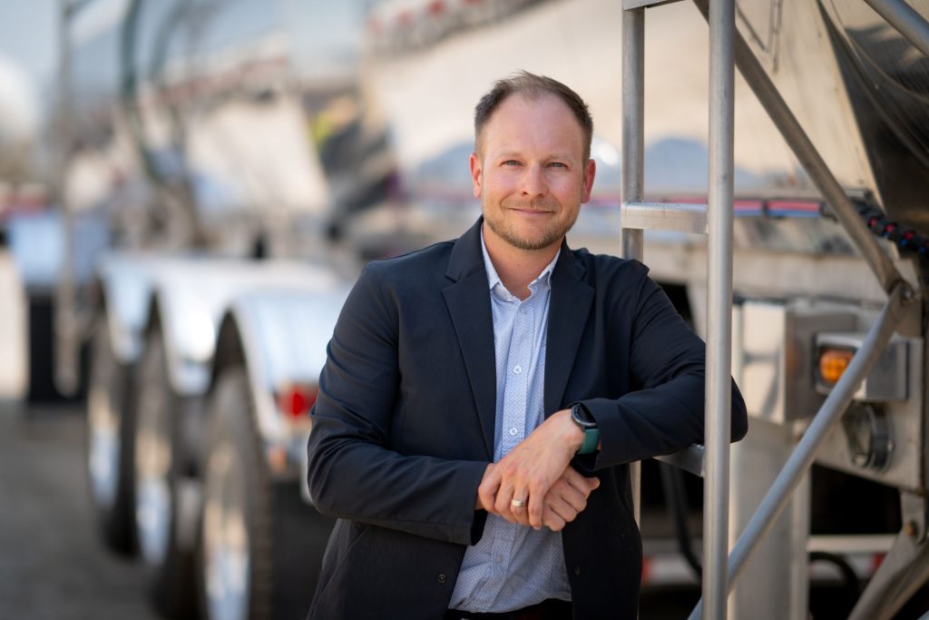 man in suit in front of tanker truck